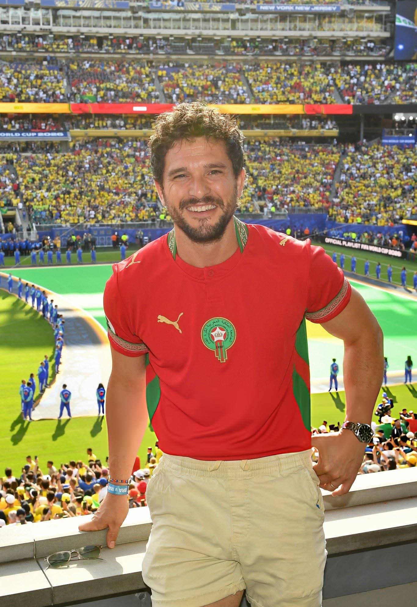 Kit Harington wearing a Morocco football shirt in a stadium setting