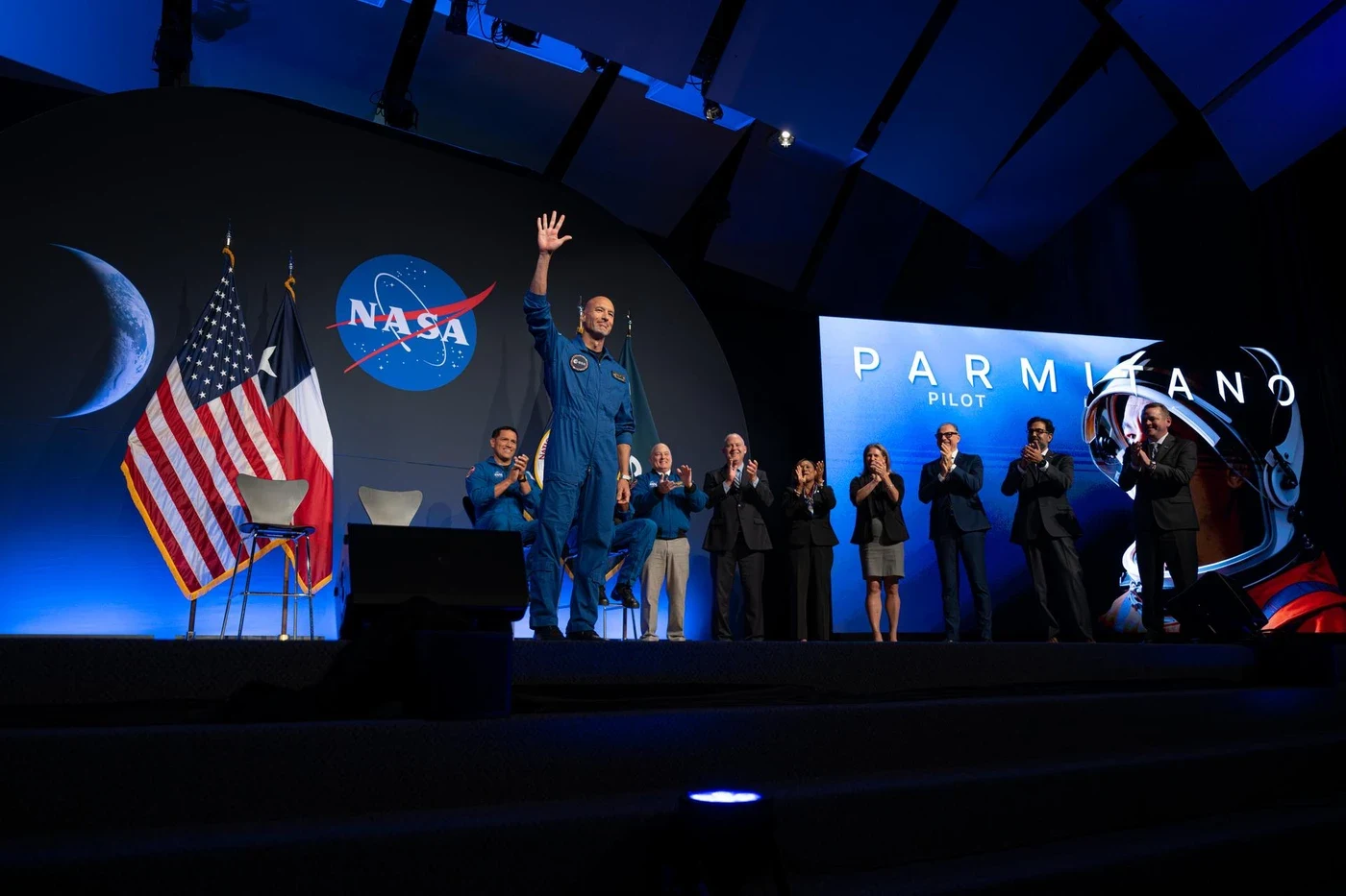 Luca Parmitano waves to the audience at the Artemis III crew announcement.
