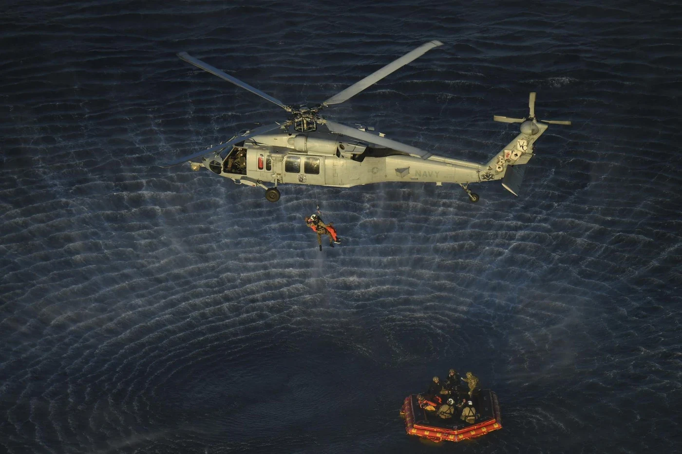Artemis II recovery operation with a raft and helicopters over the Pacific.