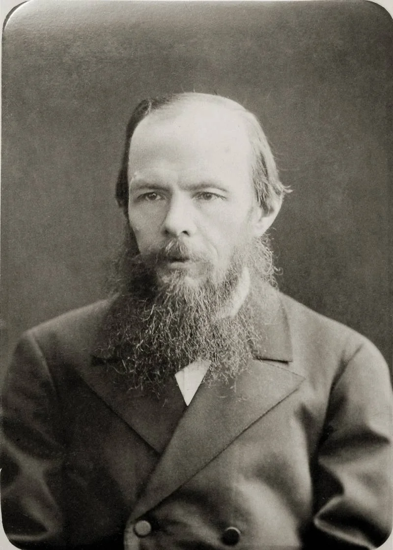 Archival studio photograph of Dostoevsky in a dark jacket, with a long beard.