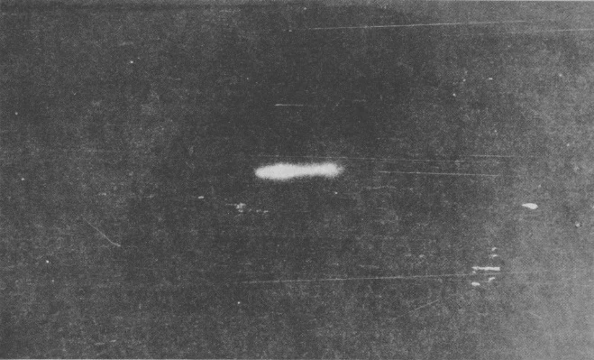 Fotografía de archivo granulada del Sputnik 2 y su etapa del cohete sobre un cielo oscuro.
