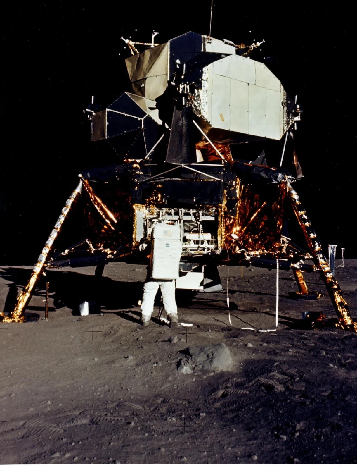 Aldrin handles experiment packages beside the lunar module’s descent stage.