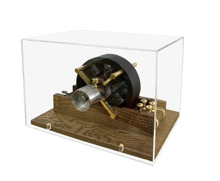 Photographie muséale d’un modèle du moteur à induction de Tesla de 1888 sous une protection transparente